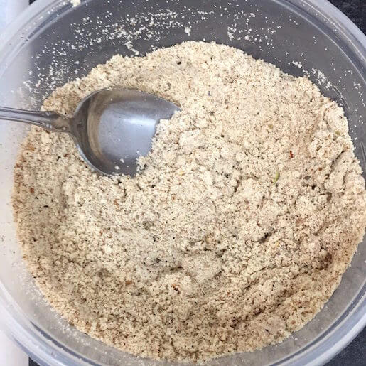 Bowl of almond flour bread crumbs with a spoon in the bowl | Root Nutrition & Education